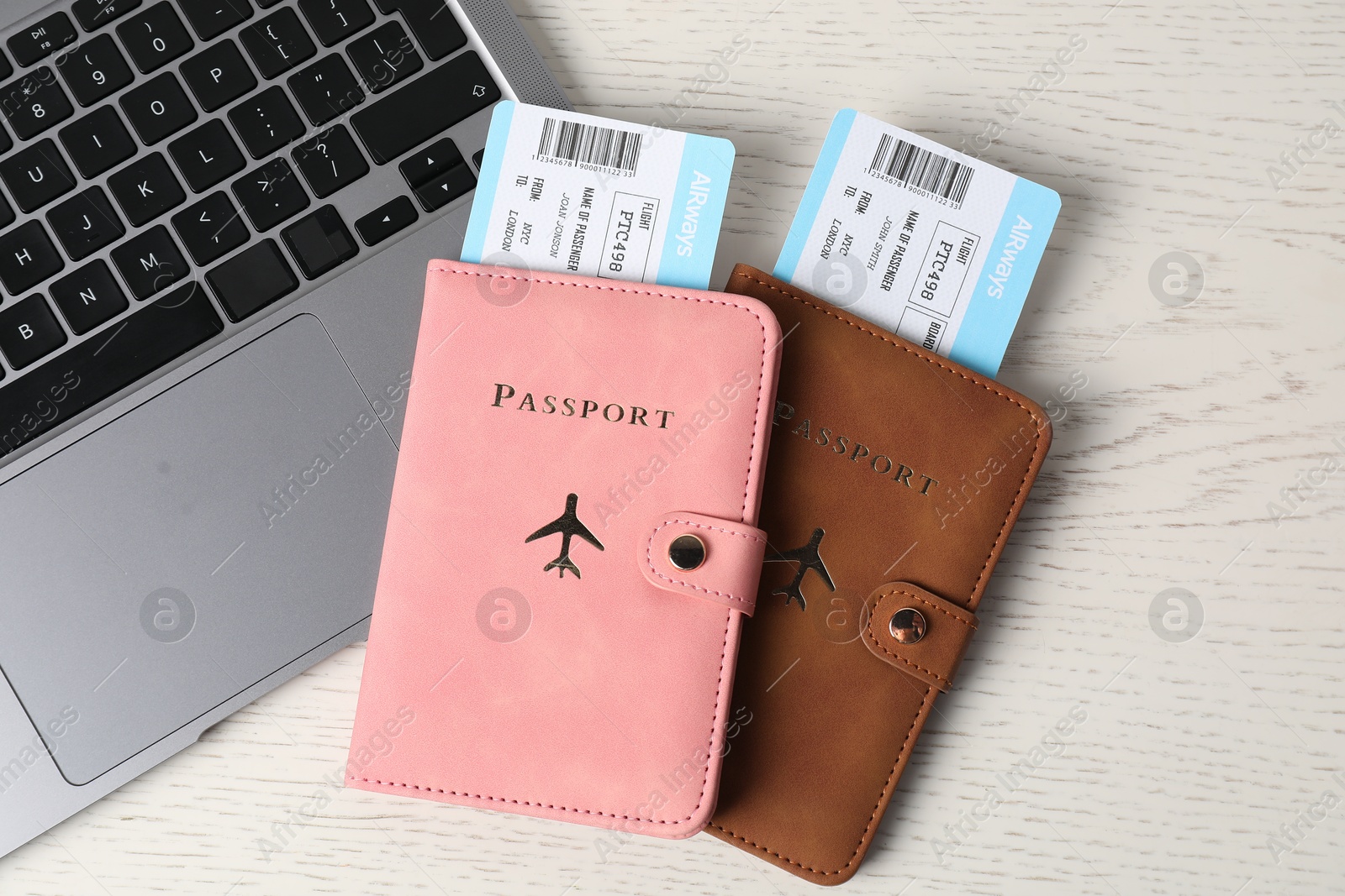 Passports, flight tickets and laptop on white wooden table, flat lay Photo of Passports, flight tickets and laptop on white wooden table, flat lay