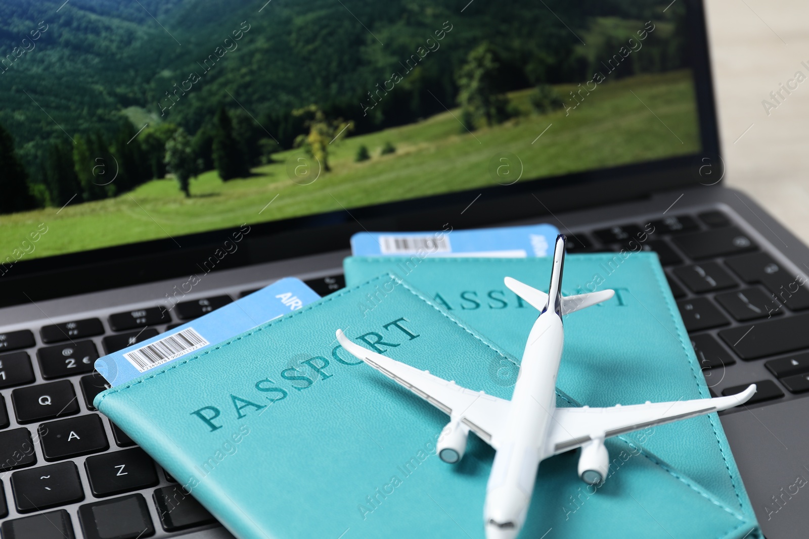 Passports, flight tickets, plane model and laptop on table, closeup Photo of Passports, flight tickets, plane model and laptop on table, closeup