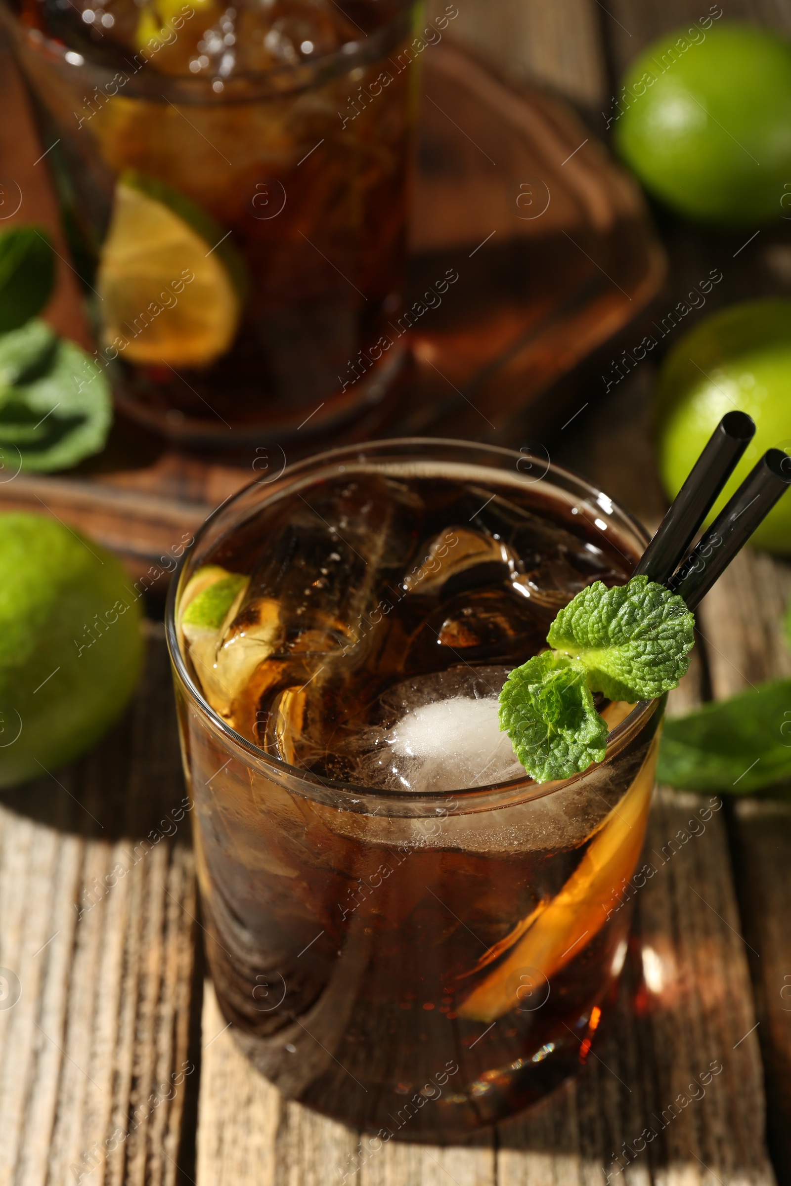 Refreshing Cuba libre cocktail with mint on wooden table Photo of Refreshing Cuba libre cocktail with mint on wooden table