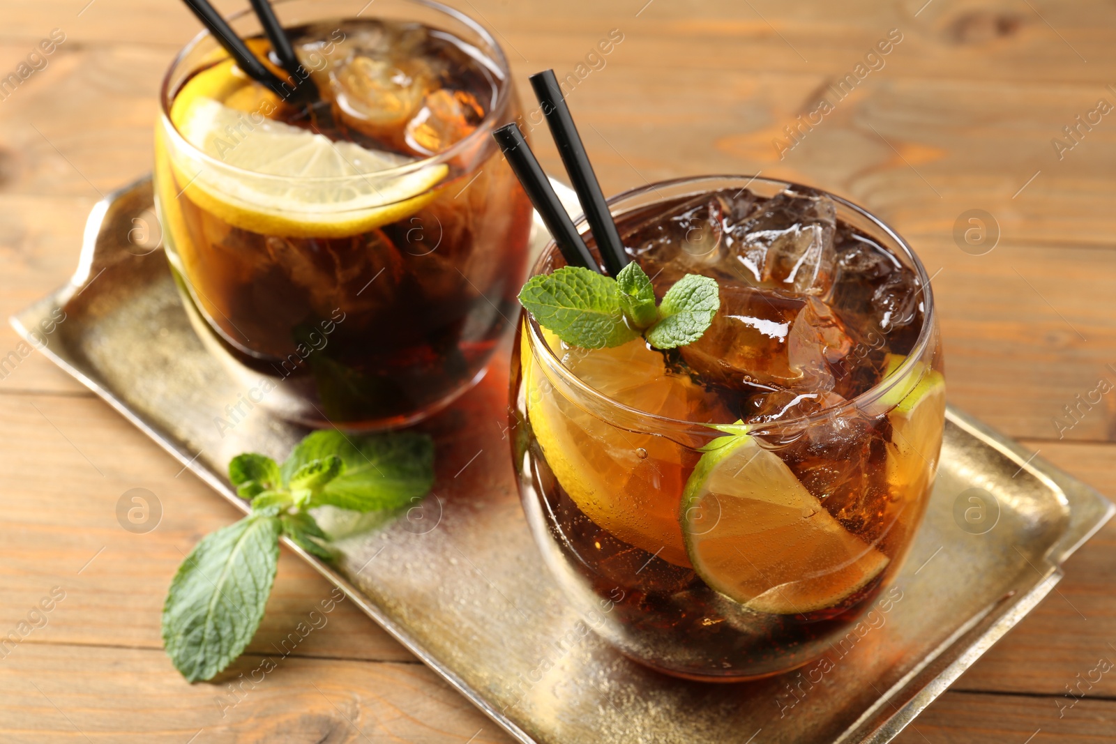 Refreshing Cuba libre cocktail with mint on wooden table, closeup Photo of Refreshing Cuba libre cocktail with mint on wooden table, closeup