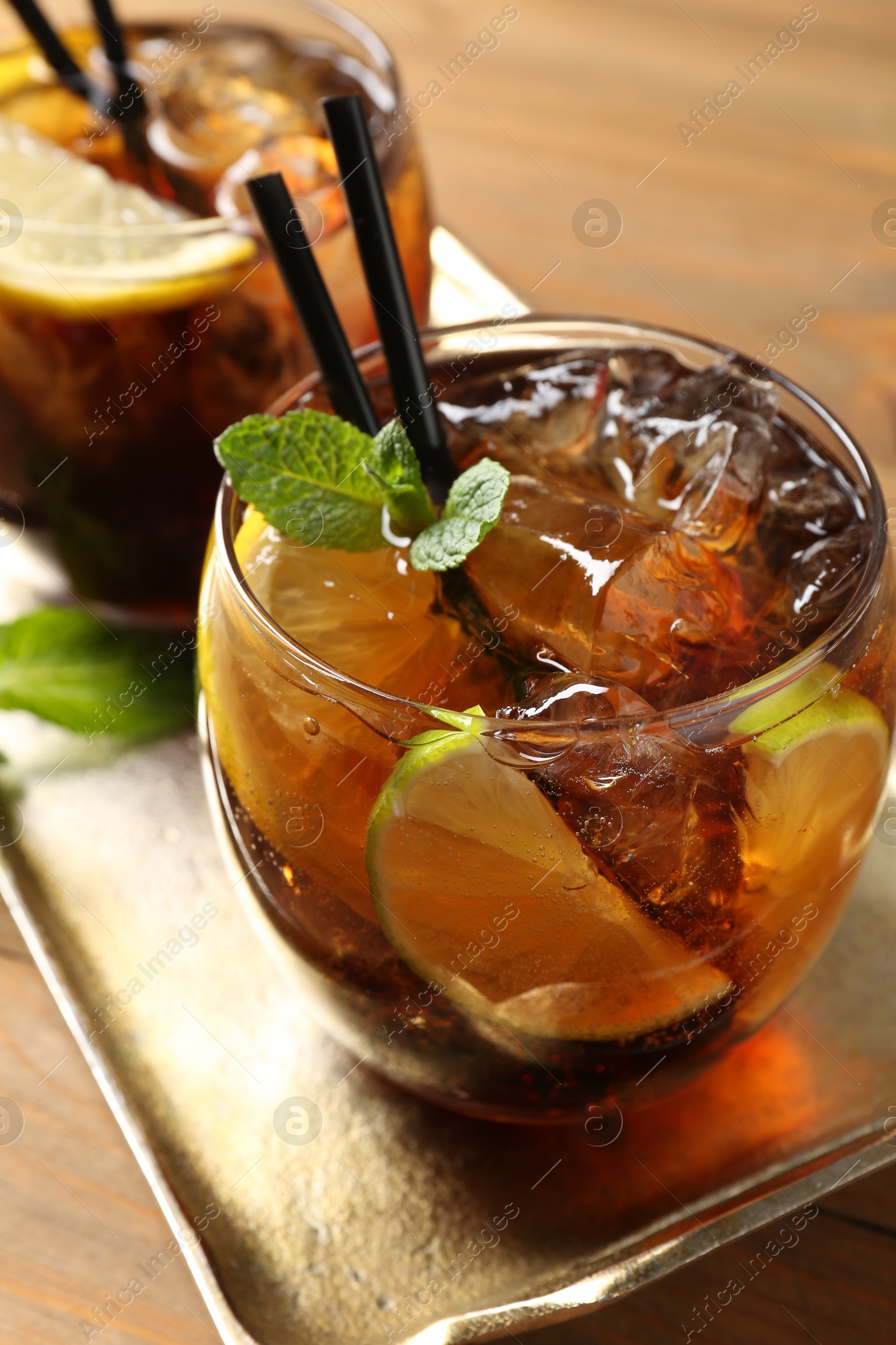 Refreshing Cuba libre cocktail with mint on wooden table, closeup Photo of Refreshing Cuba libre cocktail with mint on wooden table, closeup