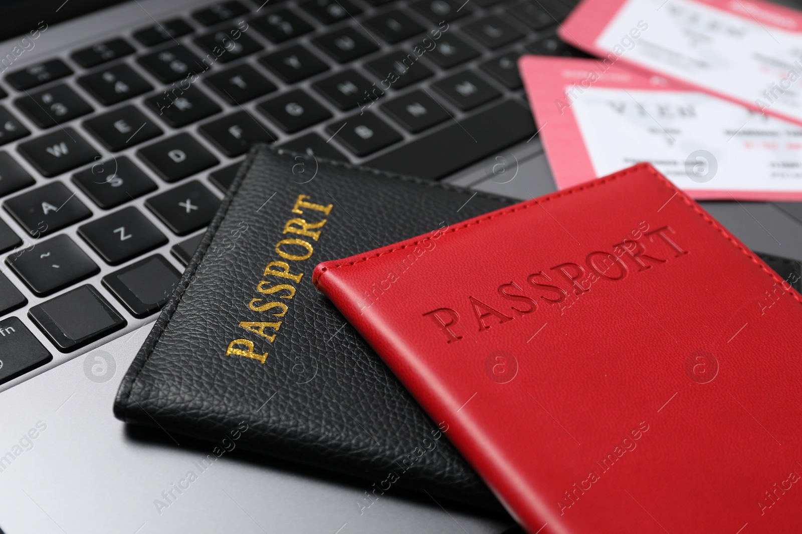 Passports and flight tickets on laptop, closeup Photo of Passports and flight tickets on laptop, closeup