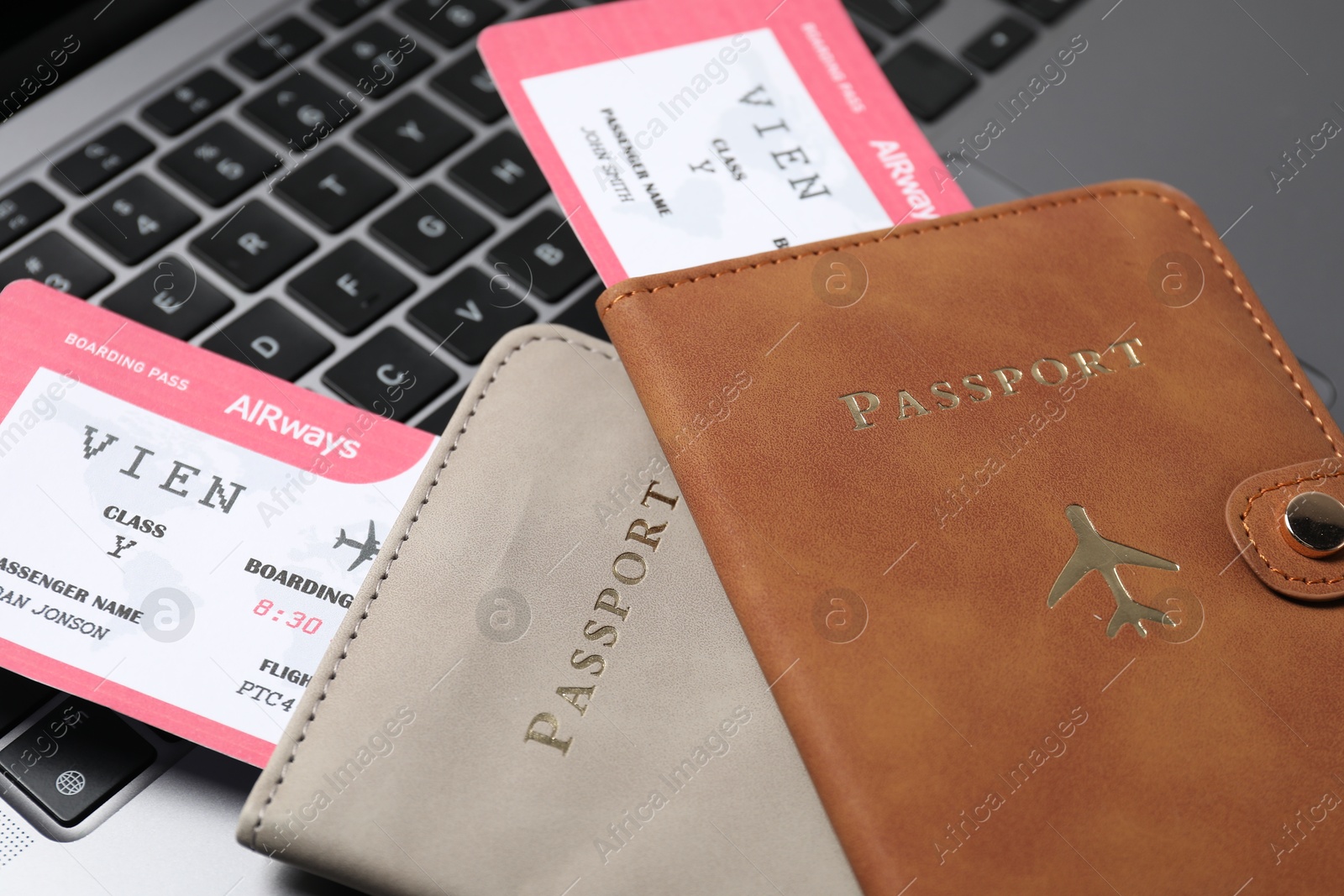 Passports and flight tickets on laptop, closeup Photo of Passports and flight tickets on laptop, closeup