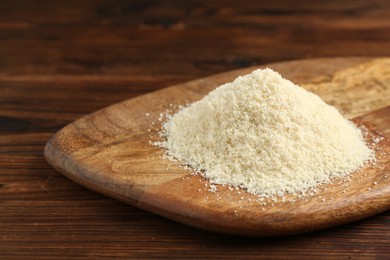 Photo of Pile of flour on wooden table, closeup. Space for text