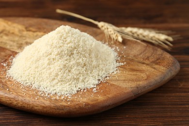 Photo of Pile of flour and spikes on wooden table, closeup