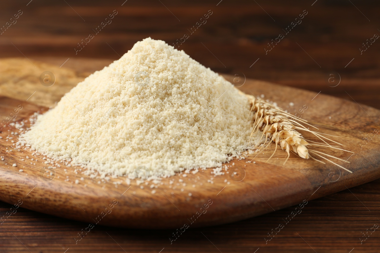 Pile of flour and spike on wooden table, closeup Photo of Pile of flour and spike on wooden table, closeup