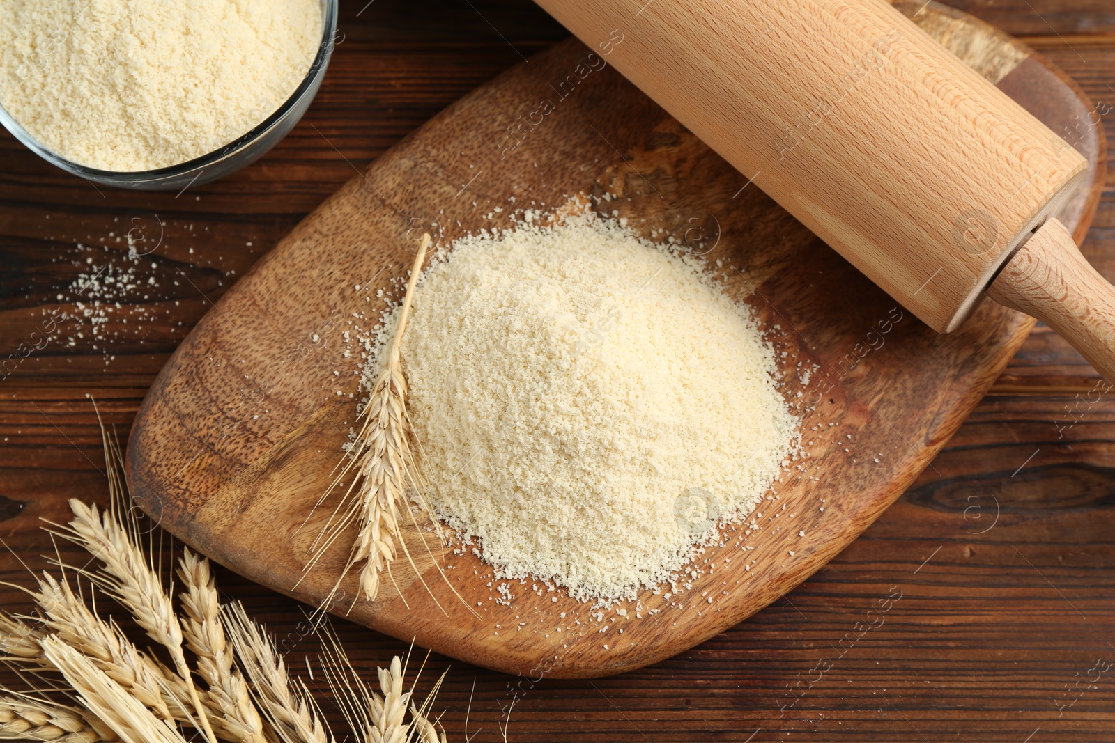Photo of Pile of flour and spikes on wooden table, flat lay