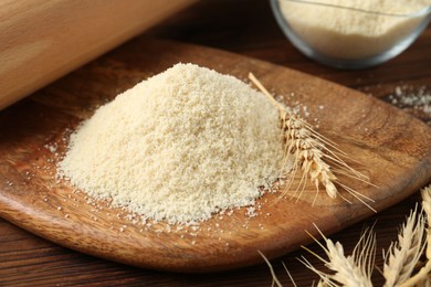 Photo of Pile of flour and spikes on wooden table, closeup