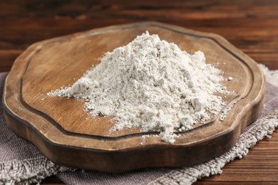 Photo of Pile of flour on wooden table, closeup
