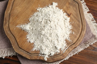Photo of Pile of flour on wooden table, top view