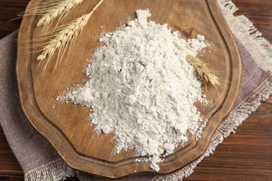 Photo of Pile of flour and spikes on wooden table, top view