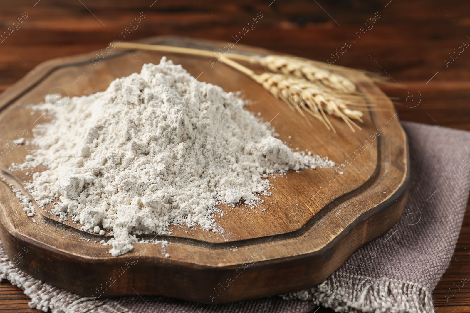 Pile of flour and spikes on wooden table, closeup Photo of Pile of flour and spikes on wooden table, closeup