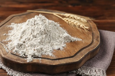 Photo of Pile of flour and spikes on wooden table, closeup