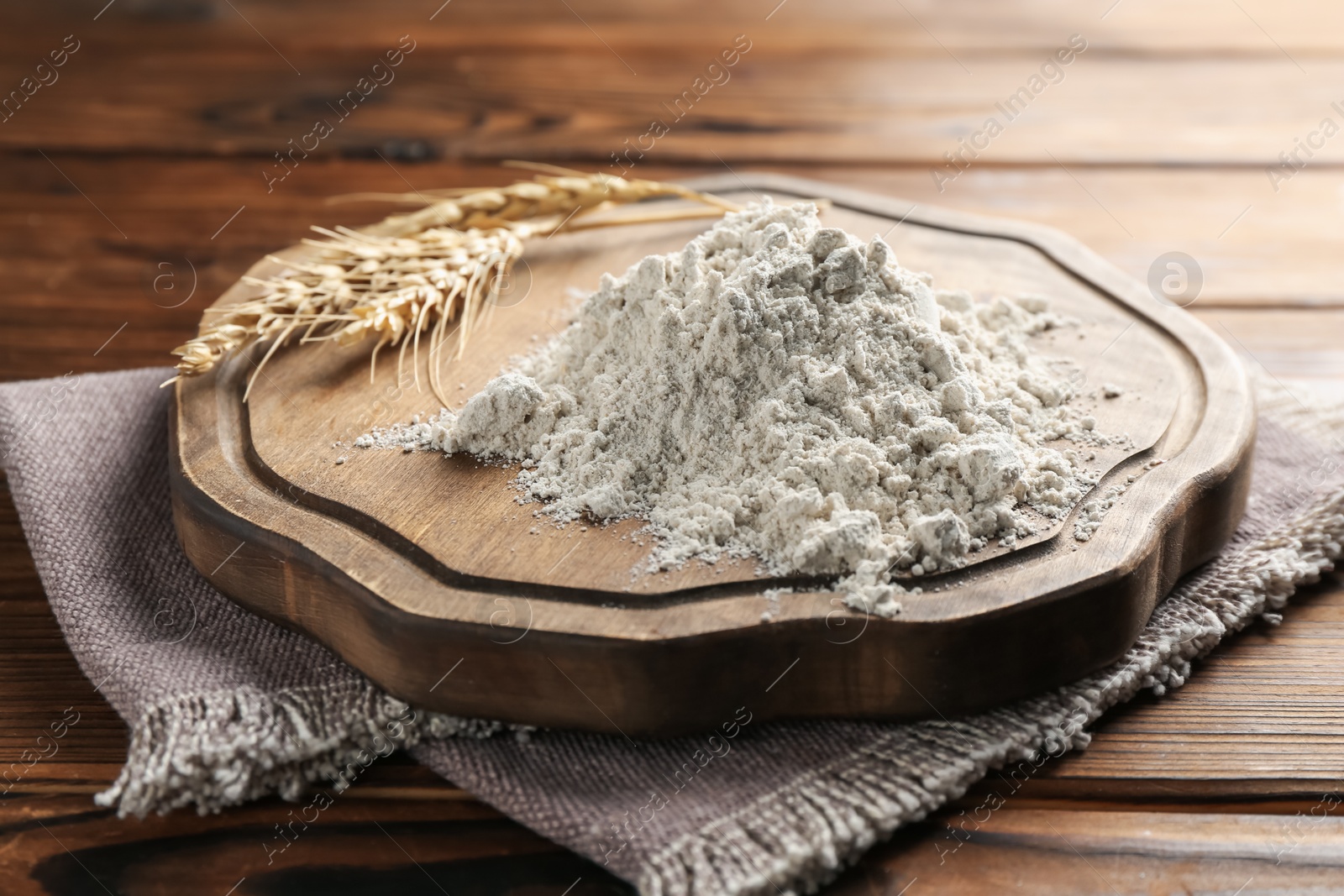 Pile of flour and spikes on wooden table, closeup Photo of Pile of flour and spikes on wooden table, closeup