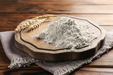 Photo of Pile of flour and spikes on wooden table, closeup