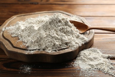 Photo of Pile of flour on wooden table, closeup