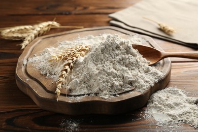 Photo of Pile of flour and spikes on wooden table, closeup