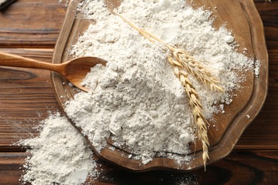 Photo of Pile of flour and spikes on wooden table, top view