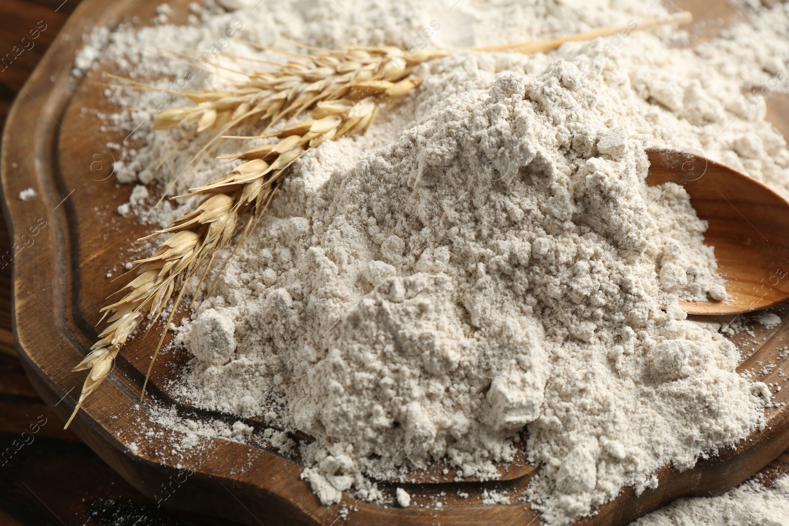 Photo of Pile of flour and spikes on wooden table, closeup
