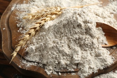Photo of Pile of flour and spikes on wooden table, closeup