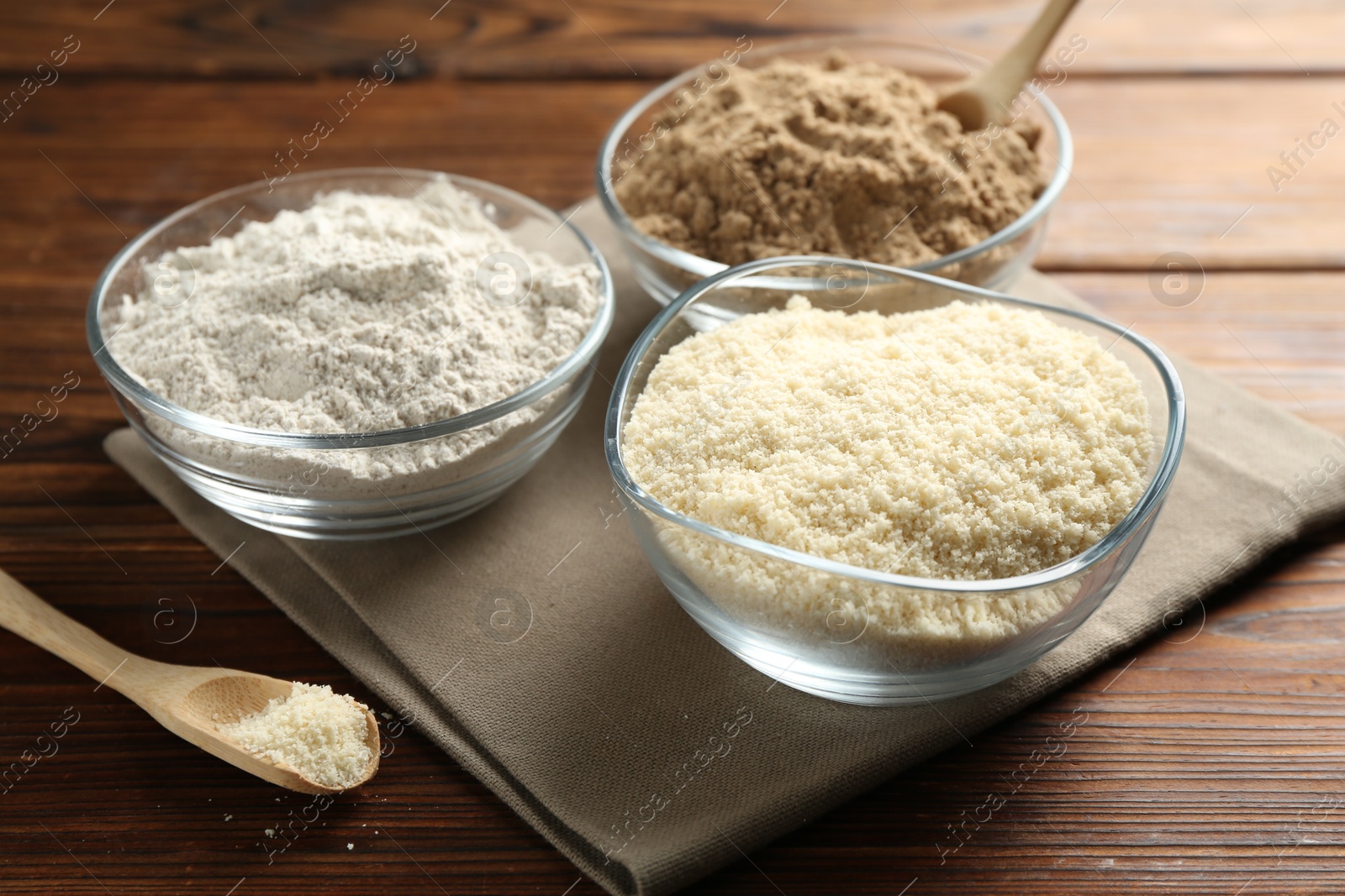 Different types of flour in bowls on wooden table, closeup Photo of Different types of flour in bowls on wooden table, closeup
