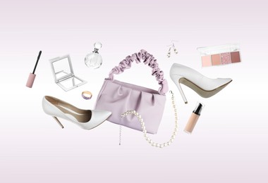 Image of Fashionable shoes, makeup products and accessories in air on light background