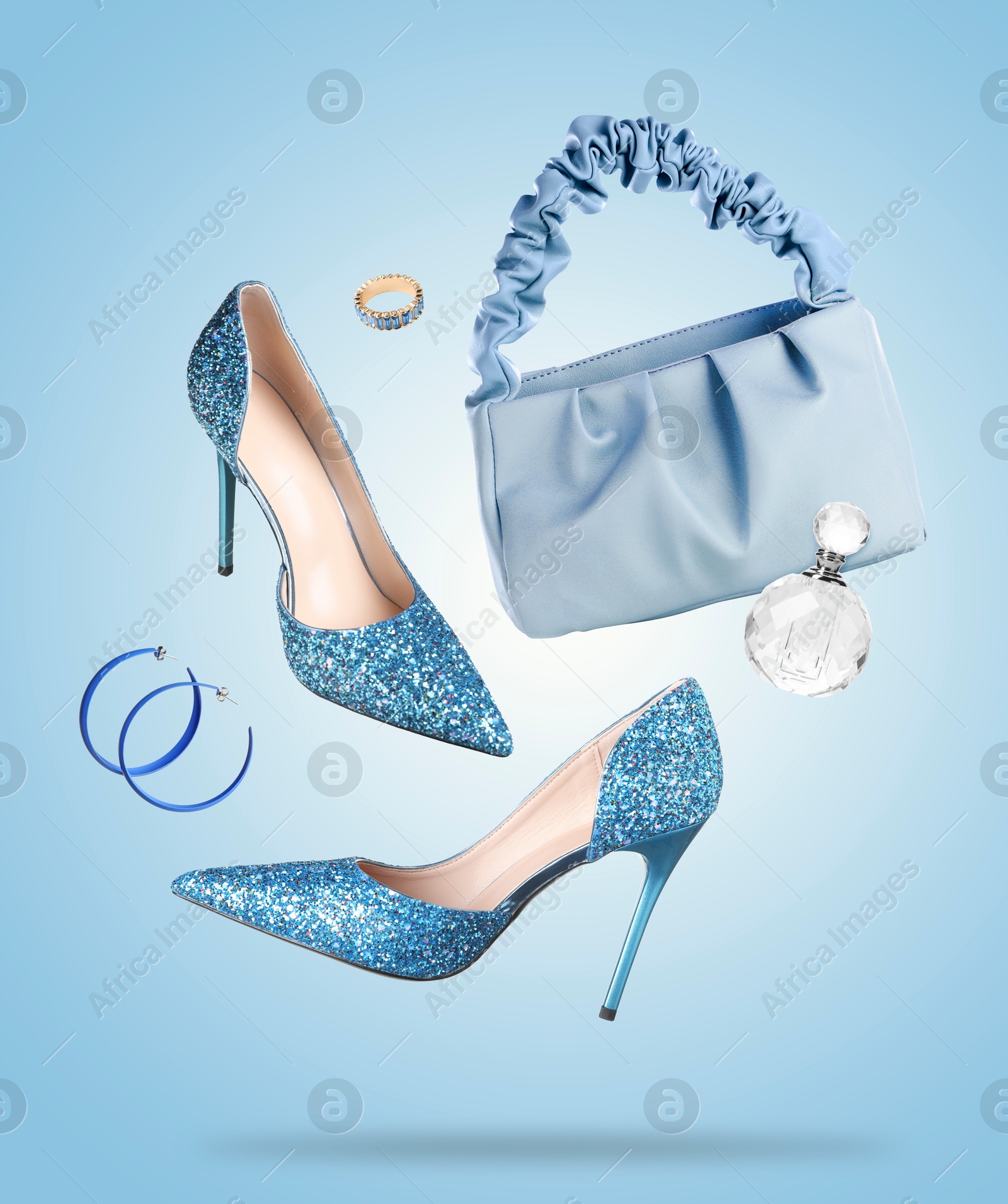 Fashionable shoes and accessories in air on light blue background Image of Fashionable shoes and accessories in air on light blue background