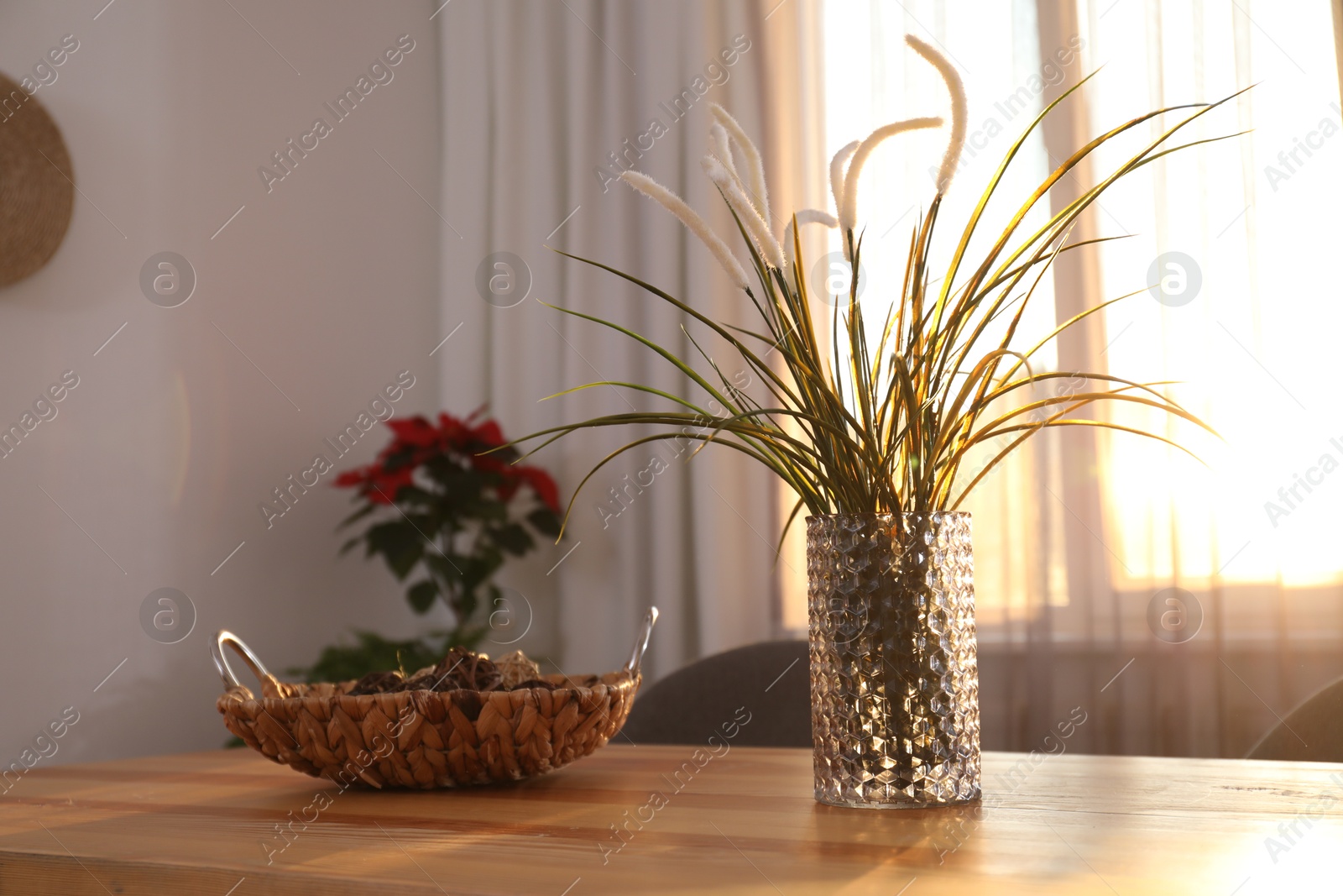 Vase on wooden table near window with curtains in room Photo of Vase on wooden table near window with curtains in room