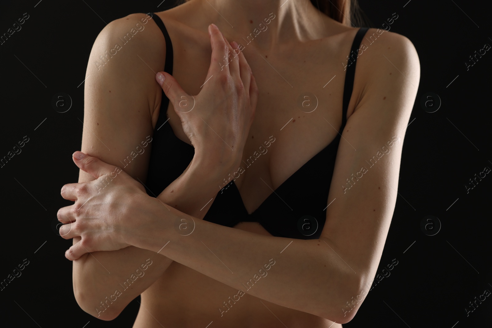 Woman in bra on black background, closeup Photo of Woman in bra on black background, closeup