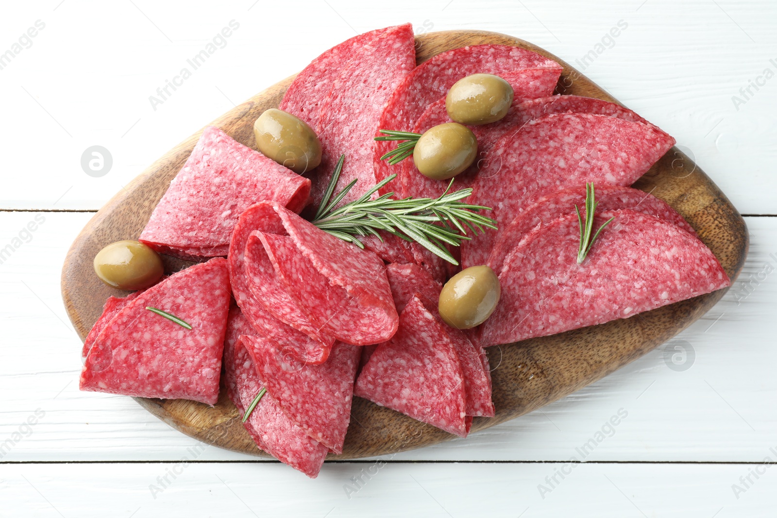 Slices of delicious sausage with olives and rosemary served on white wooden table, top view Photo of Slices of delicious sausage with olives and rosemary served on white wooden table, top view