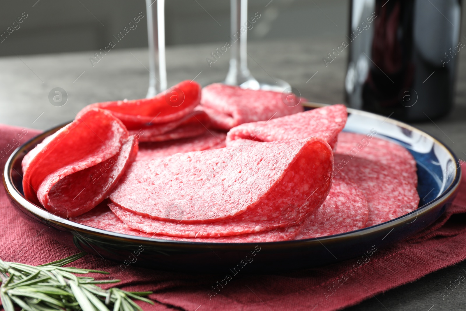 Slices of delicious sausage served on grey table, closeup Photo of Slices of delicious sausage served on grey table, closeup