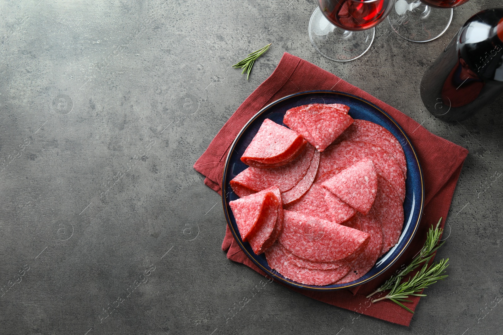 Slices of delicious sausage served on grey table, flat lay. Space for text Photo of Slices of delicious sausage served on grey table, flat lay. Space for text