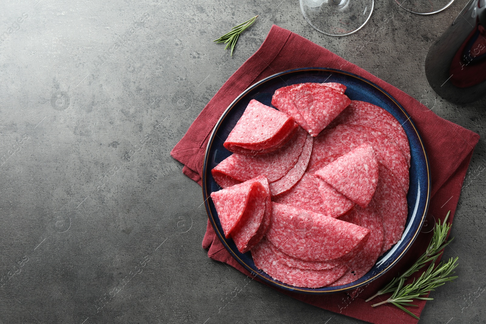 Slices of delicious sausage served on grey table, flat lay. Space for text Photo of Slices of delicious sausage served on grey table, flat lay. Space for text
