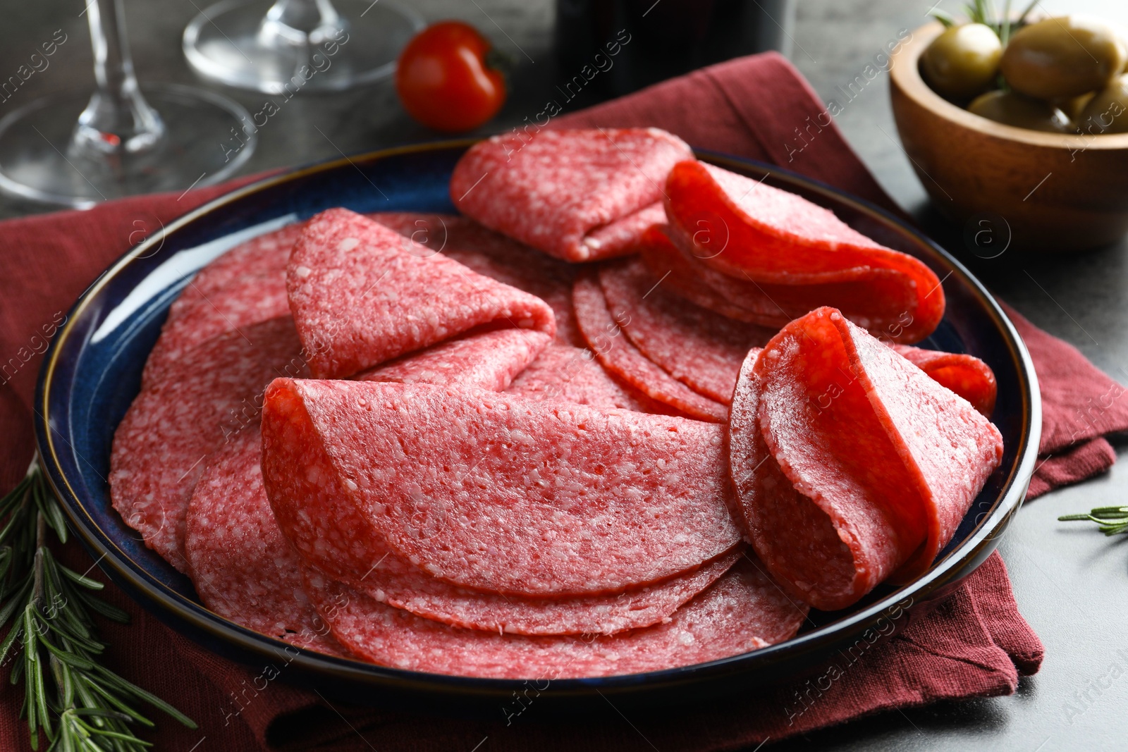 Slices of delicious sausage served on grey table, closeup Photo of Slices of delicious sausage served on grey table, closeup