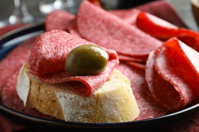 Photo of Sandwich with delicious sausage and olive served on table, closeup
