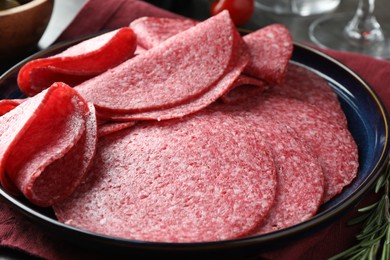 Photo of Slices of delicious sausage served on table, closeup