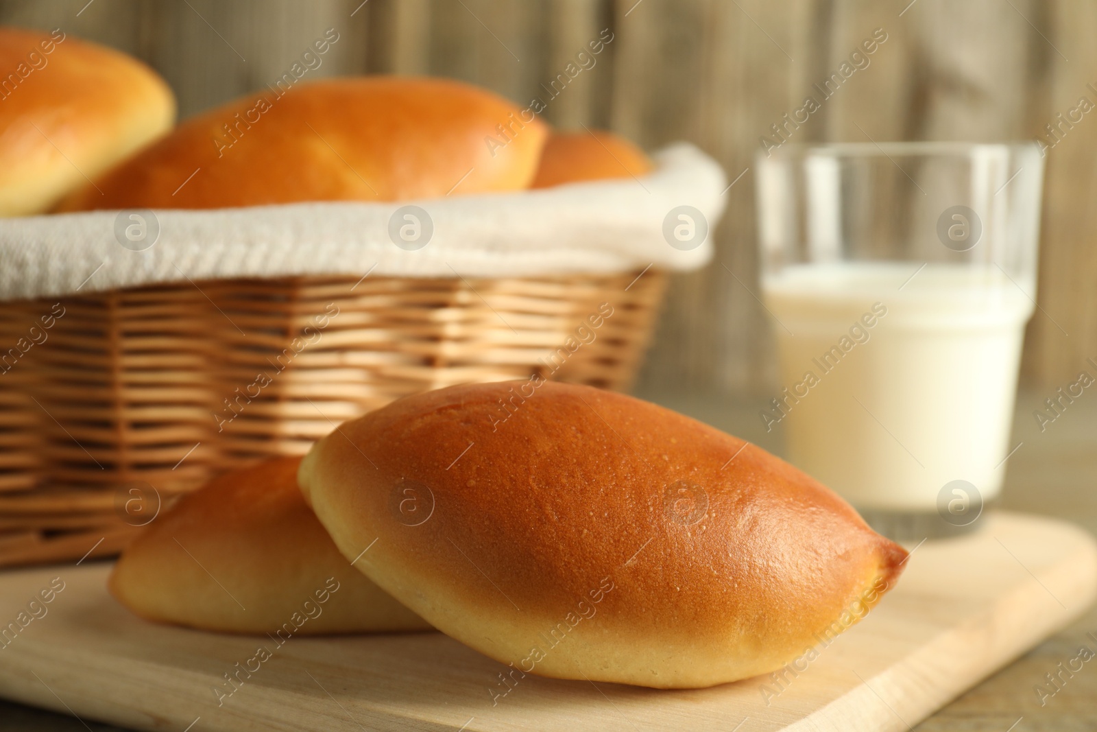 Tasty baked patties and milk on wooden table, closeup Photo of Tasty baked patties and milk on wooden table, closeup