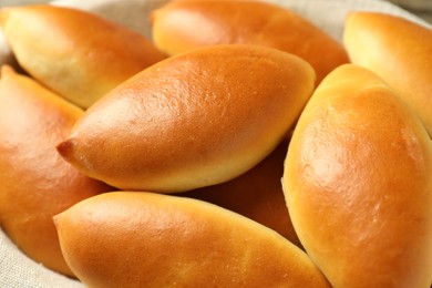 Photo of Many tasty baked patties in basket, closeup