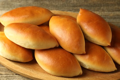Photo of Tasty baked patties on wooden table, closeup