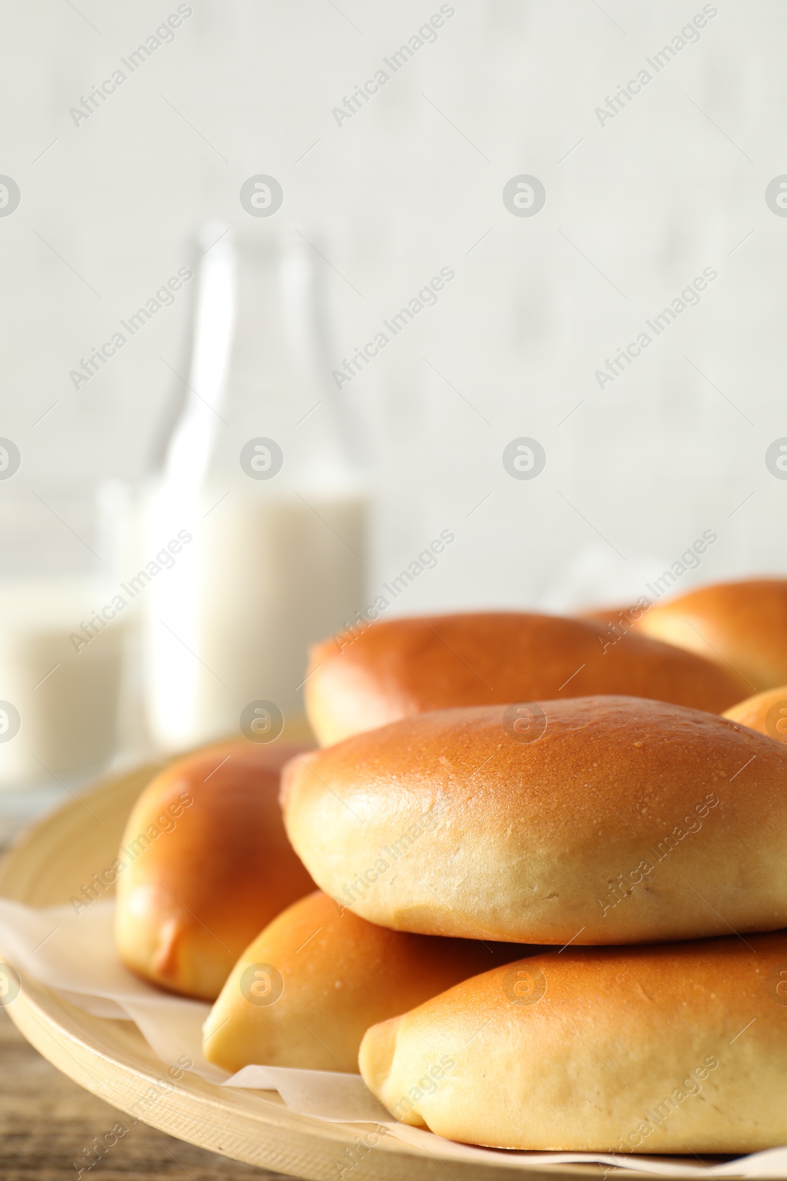 Tasty baked patties and milk on wooden table, closeup. Space for text Photo of Tasty baked patties and milk on wooden table, closeup. Space for text