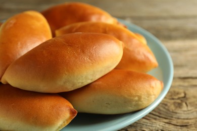 Photo of Tasty baked patties on wooden table, closeup