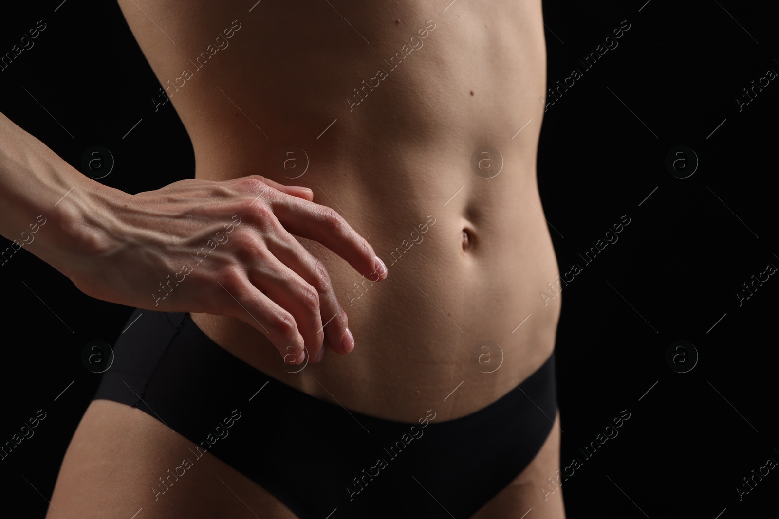 Slim woman in panties on black background, closeup Photo of Slim woman in panties on black background, closeup