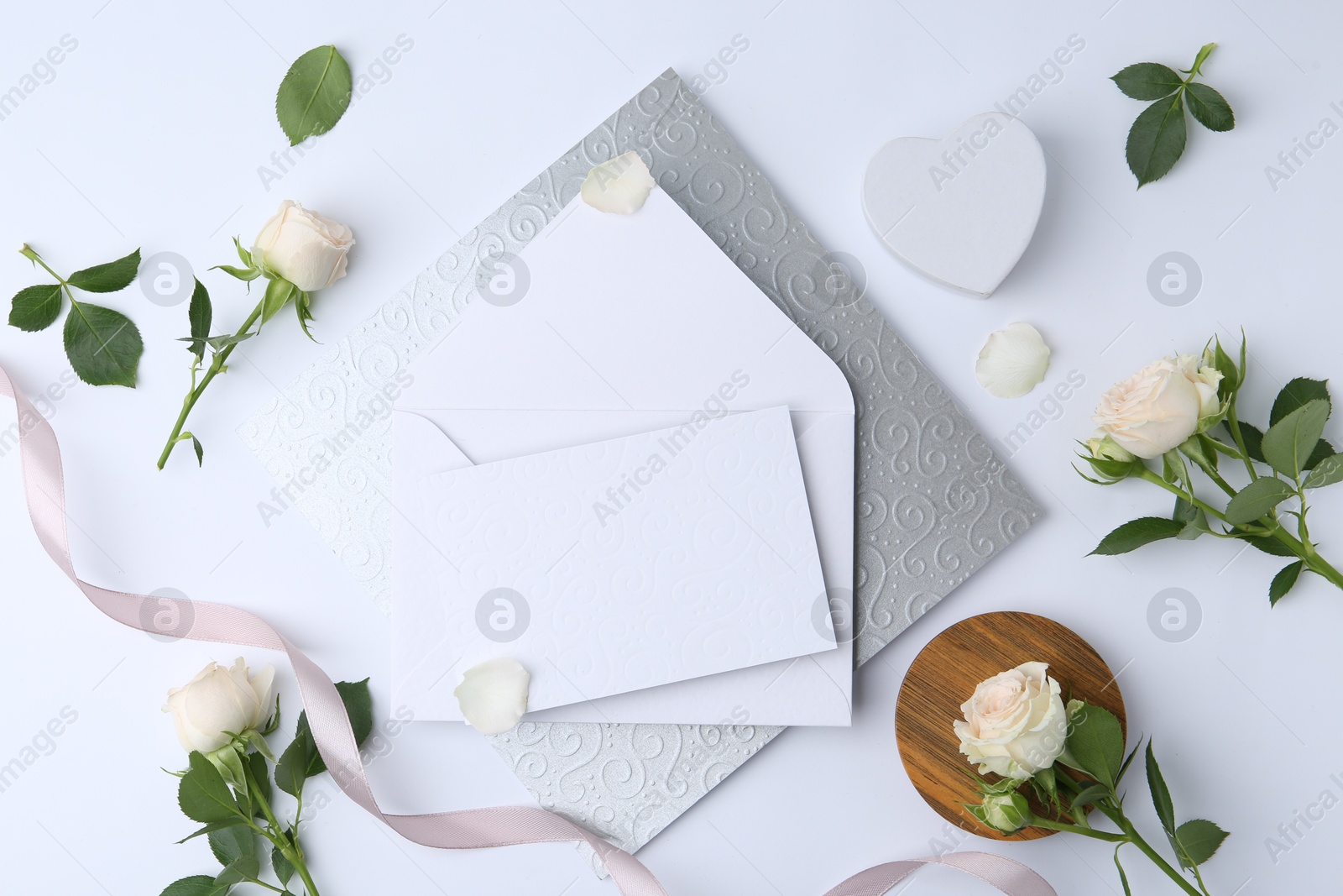 Flat lay composition with blank greeting card and flowers on white background Photo of Flat lay composition with blank greeting card and flowers on white background