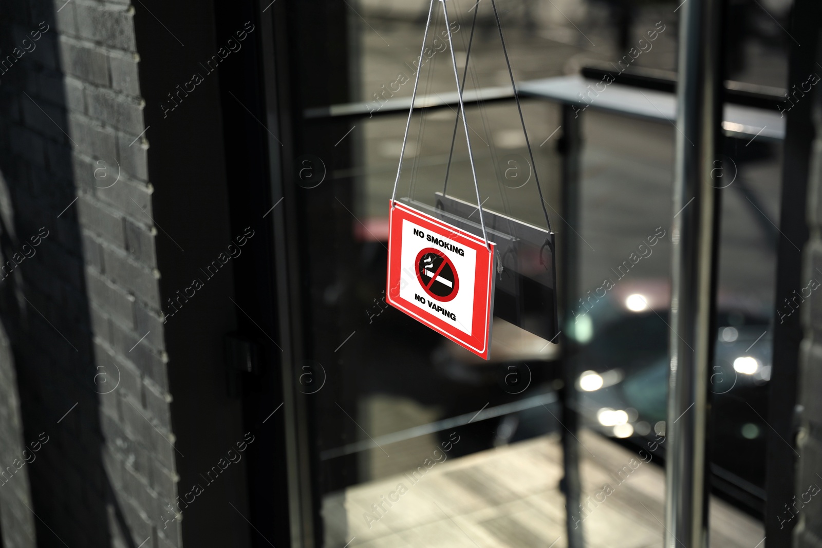 No Smoking sign hanging on entrance door Image of No Smoking sign hanging on entrance door