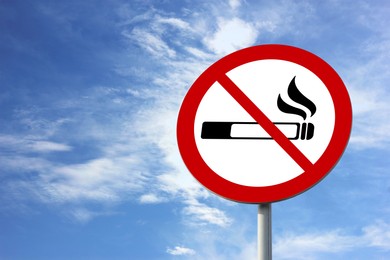 Image of No Smoking sign against blue sky with clouds
