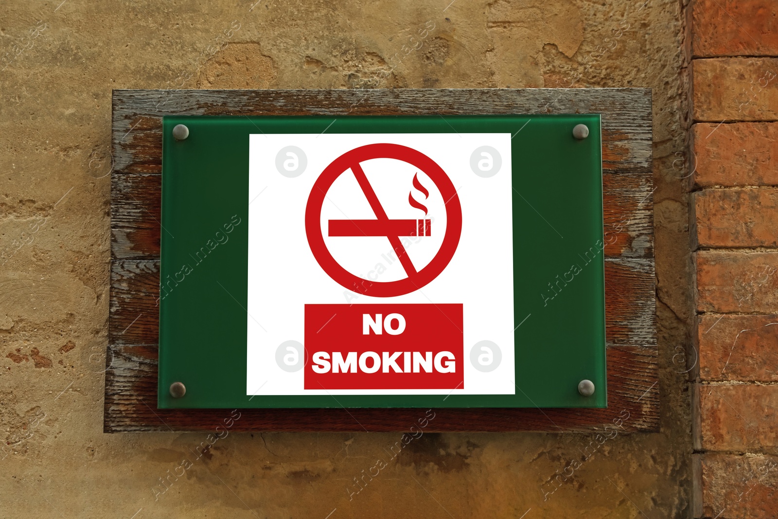 No Smoking sign on building wall outdoors Image of No Smoking sign on building wall outdoors