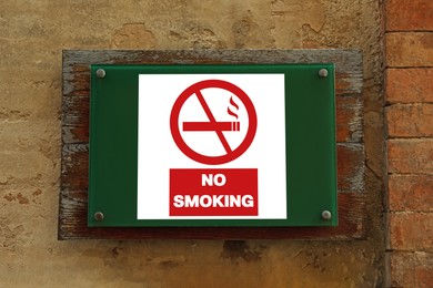 Image of No Smoking sign on building wall outdoors