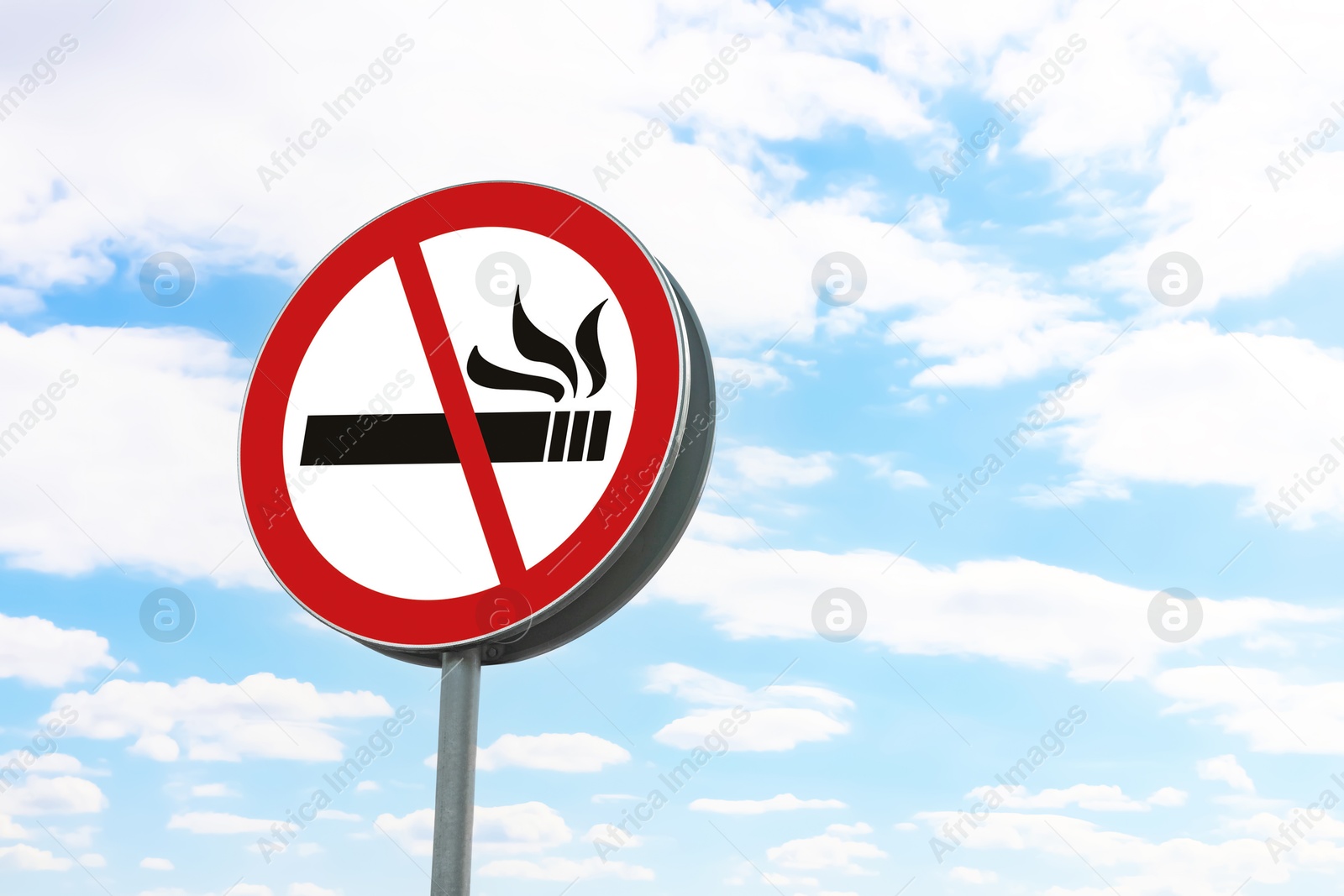 Image of No Smoking sign against blue sky with clouds