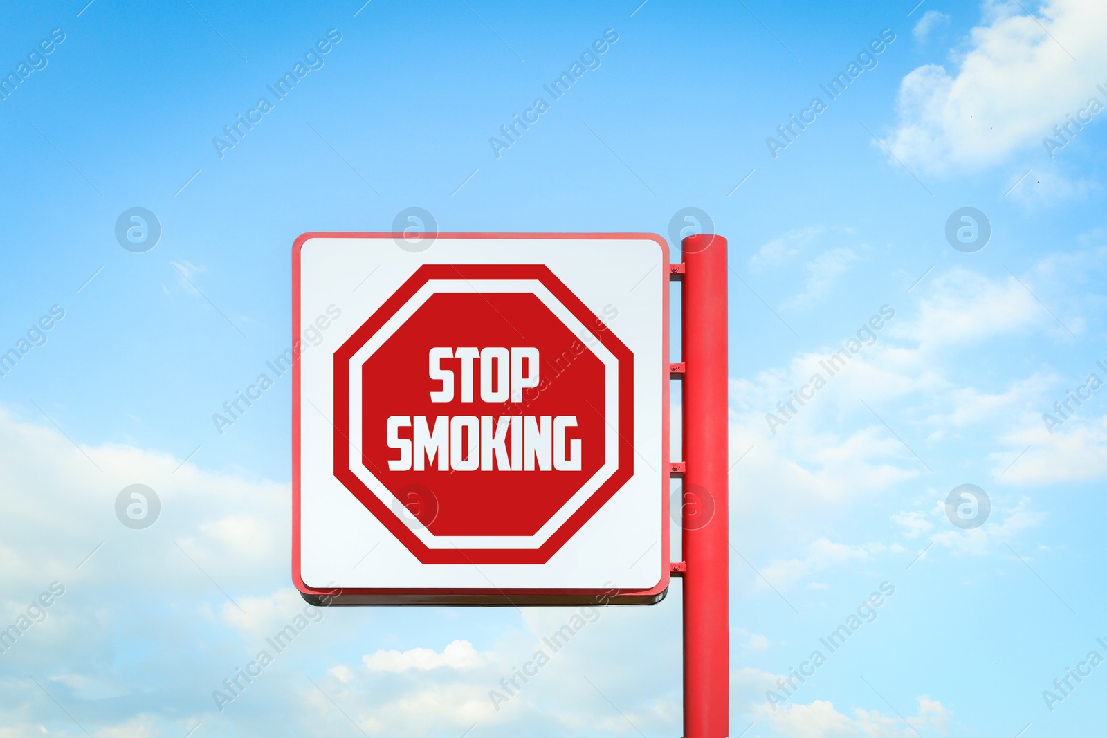 Image of Stop Smoking sign against blue sky with clouds