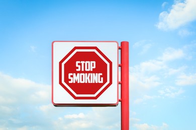 Image of Stop Smoking sign against blue sky with clouds